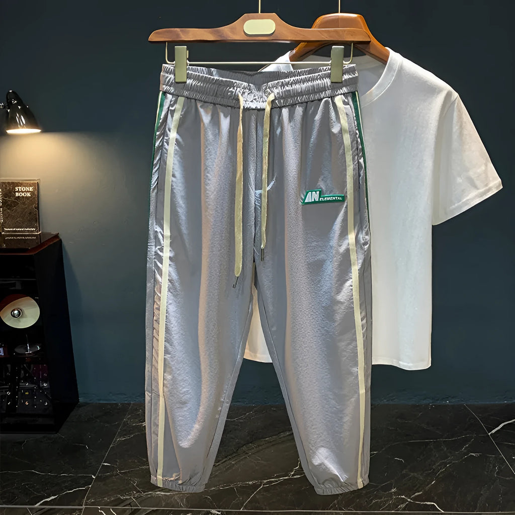 Men's solid black cotton harem pants laid flat, showing relaxed fit and mid waist design.