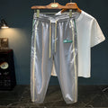 Men's solid black cotton harem pants laid flat, showing relaxed fit and mid waist design.