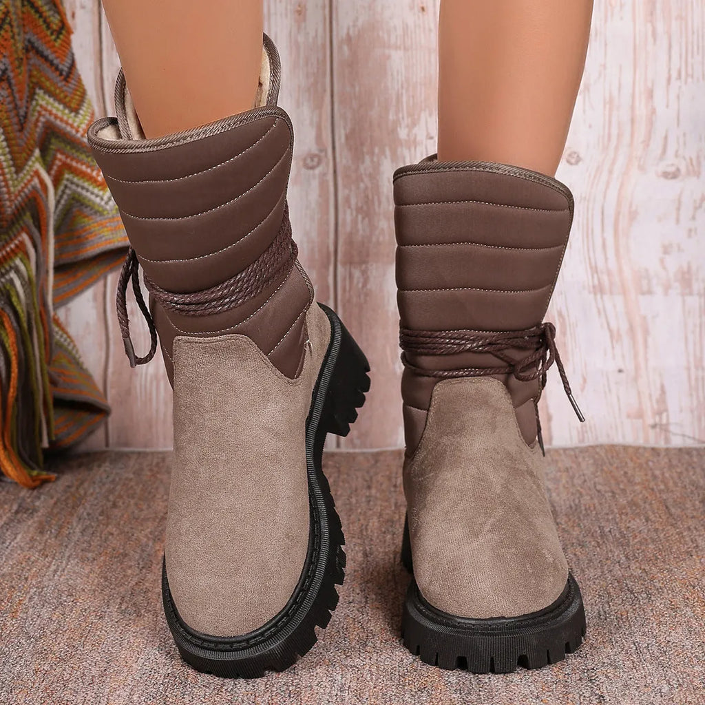 Women's black chunky heel snow boot with lace-up design and suede upper on a white background.