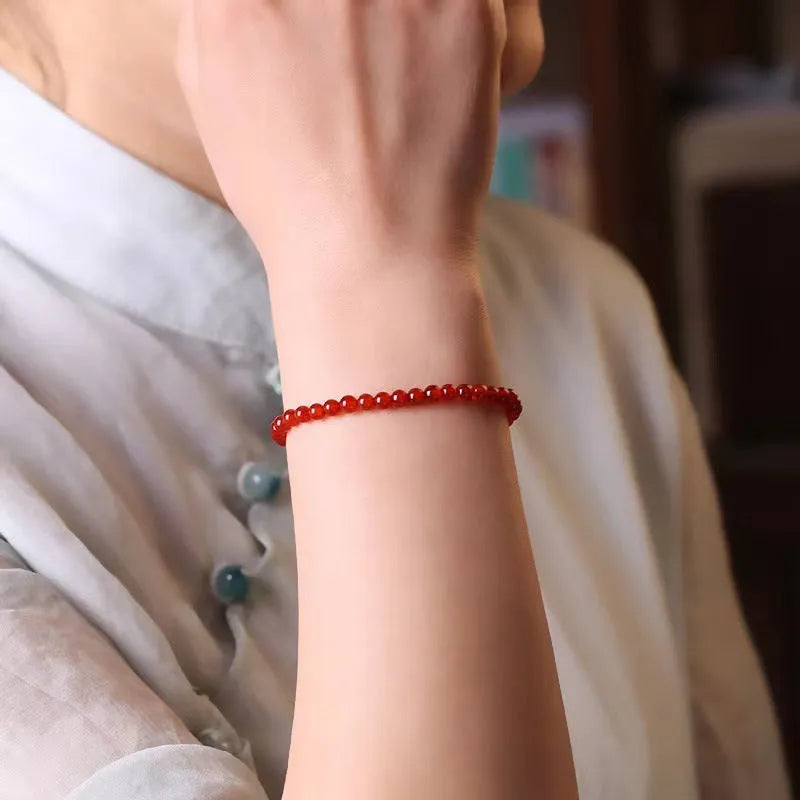 Ultra-thin red agate small bracelet for women, classic style, on a plain background.
