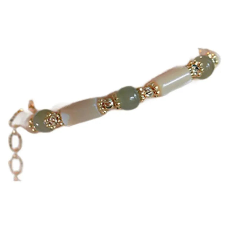 Natural Hetian jade white lip shell round bead bracelet for women on a neutral background