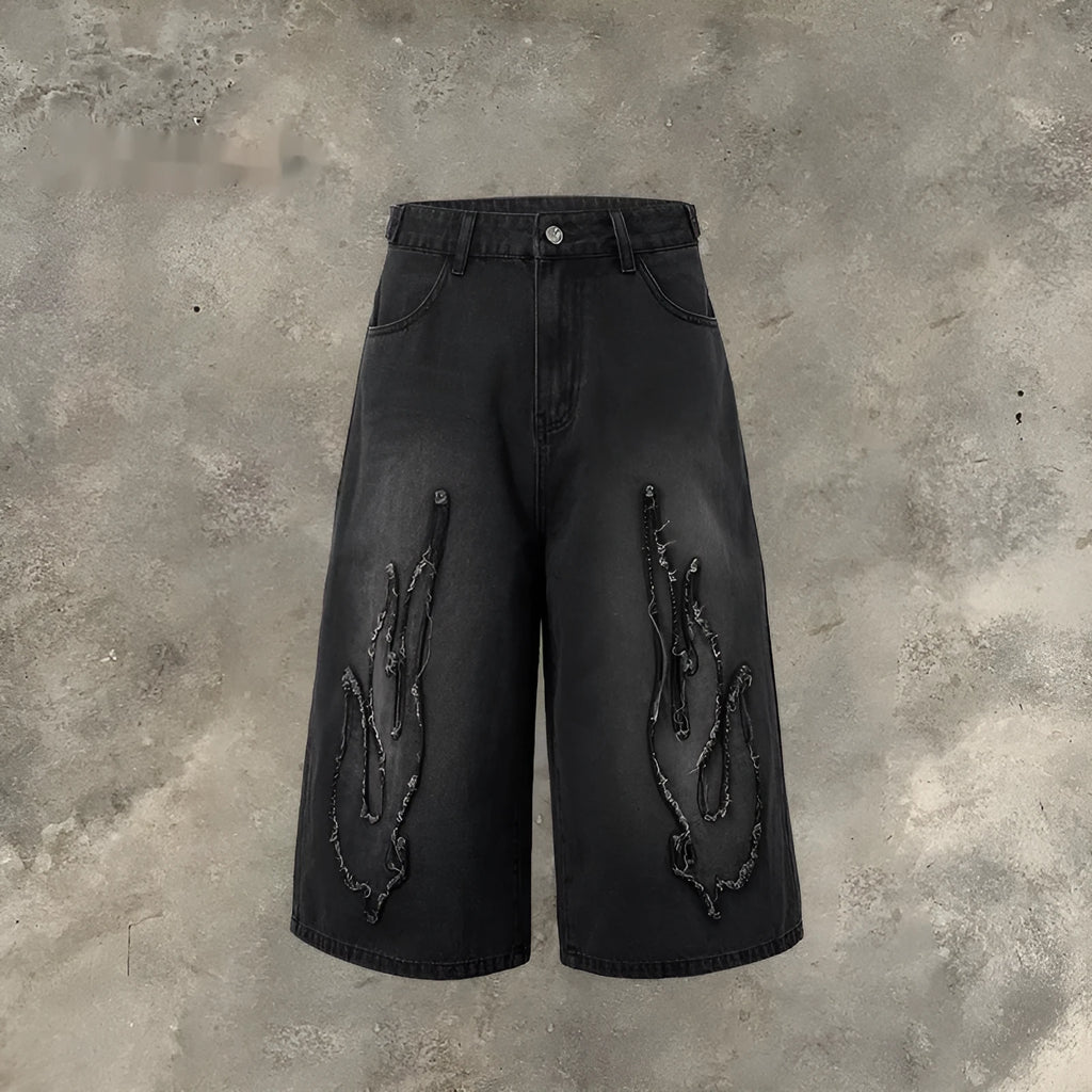 Men's black denim shorts with cropped flame embroidery patch on leg, straight cut.