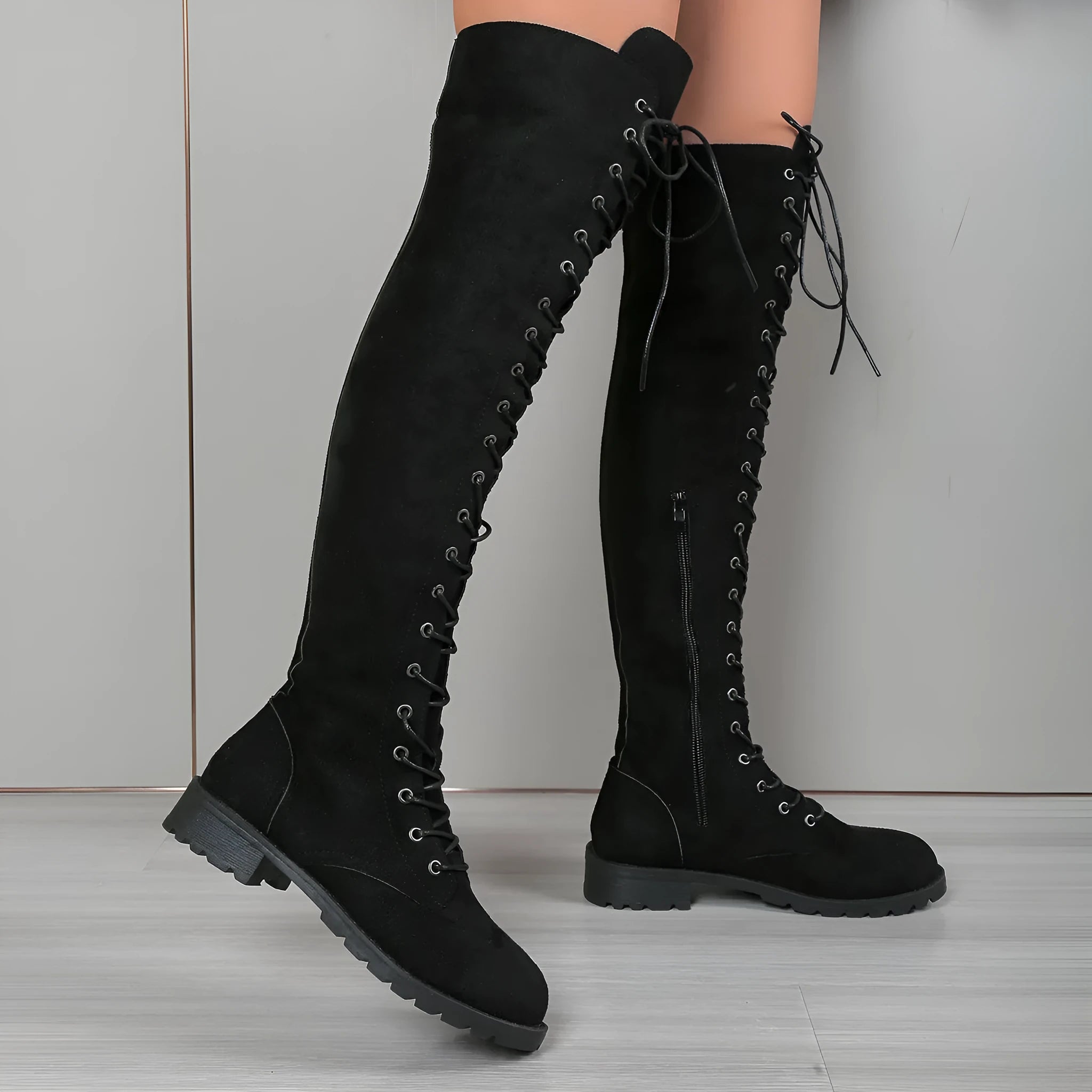 Women's black lace-up over the knee flat boots with round toe on a white background.