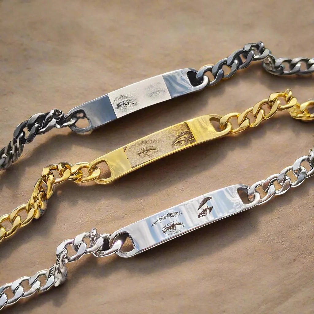 Personalised stainless steel bracelet with laser engraved human eye design, available in black, gold, and silver finishes