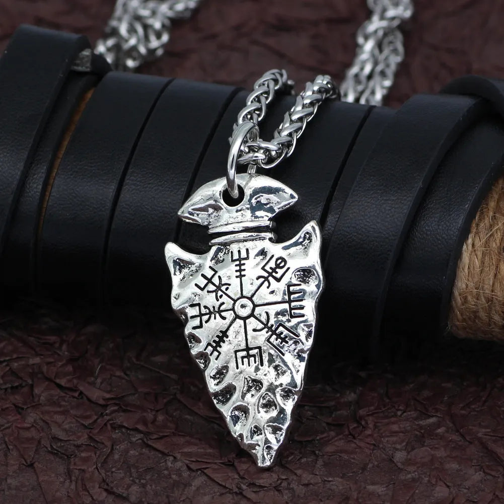 Alloy compass pendant necklace with twisted chain on a flat surface showing silver finish