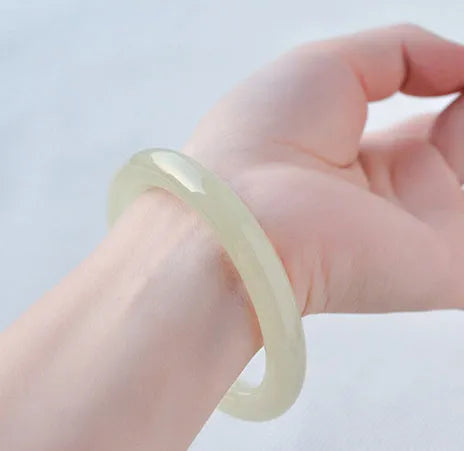 Ice-like silk jade round bar bracelet on neutral background showing smooth surface and circular shape