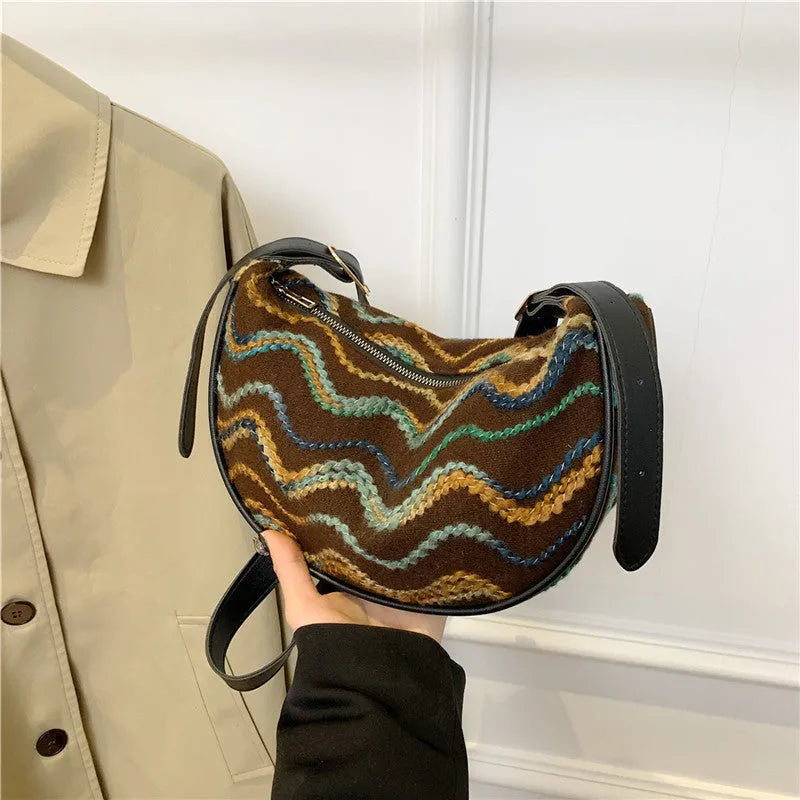 Women's knitted straw woven crossbody bag showing woven texture and internal phone and document pockets