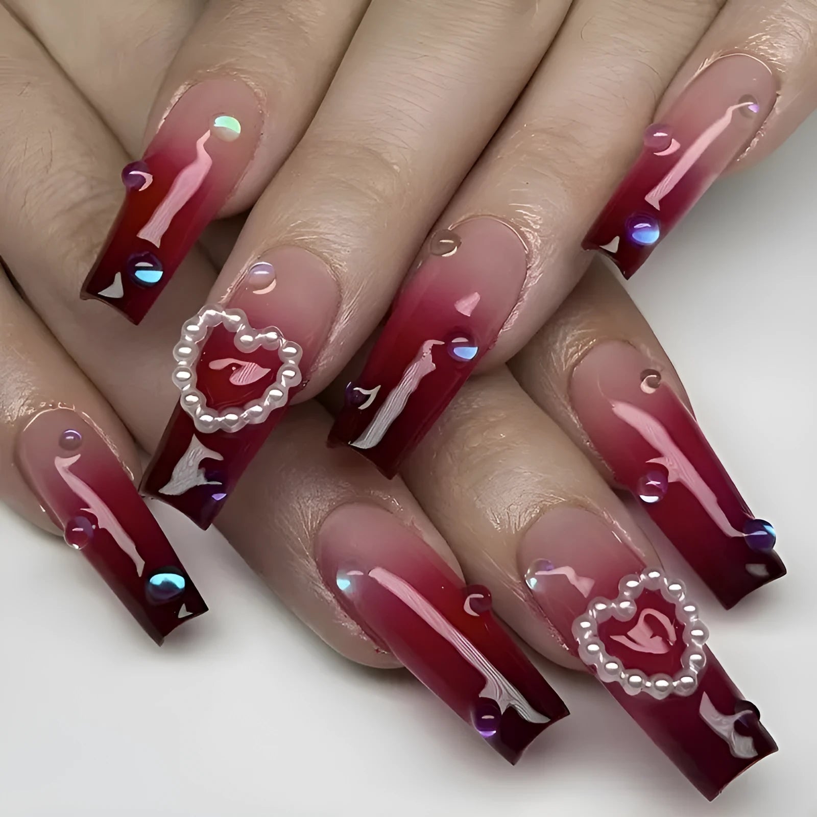 Wine red gradient fake nail tips with pearl heart decoration and plaid pattern in long ballet length style.