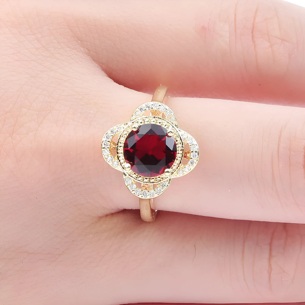 Close-up of a fruit-shaped copper ring with an electroplated finish and an inlaid zircon, shown on a hand.