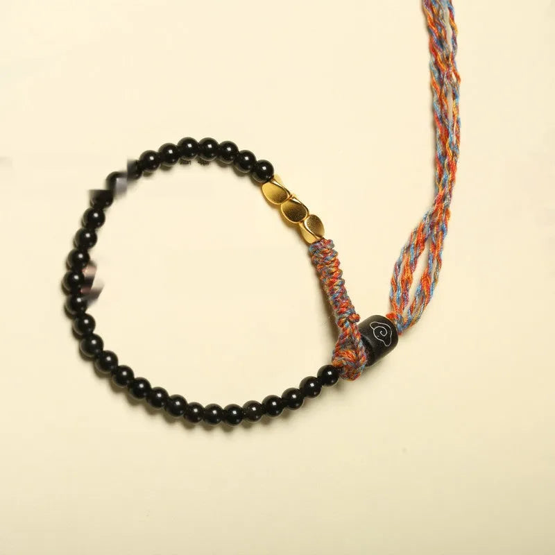 Obsidian coloured hand-woven leather strap bracelet with adjustable fastening on a wrist.