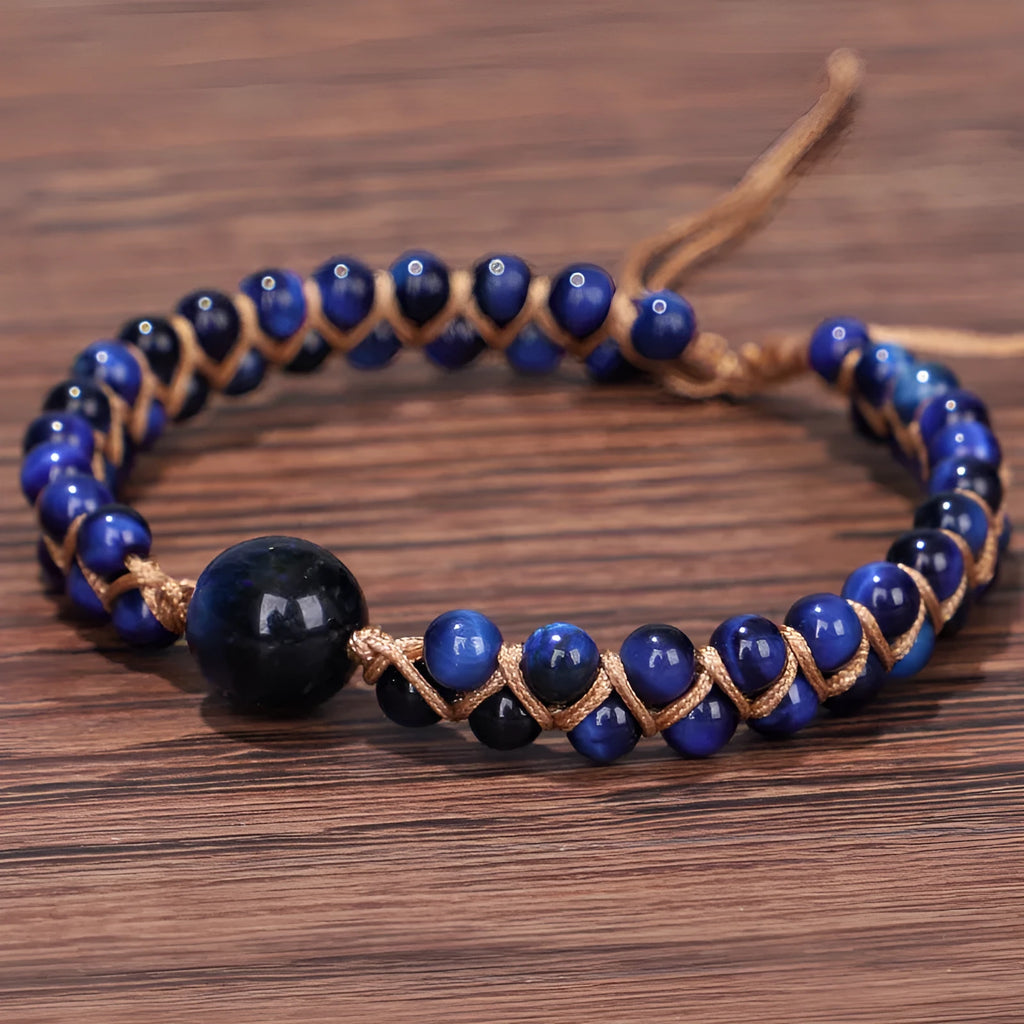 Handmade woven geometric pull bracelet with blue Tigereye stone beads on a wrist.