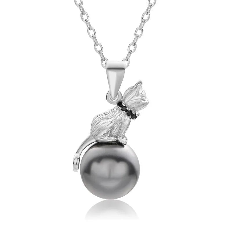 Close-up of a sterling silver cat pendant necklace on a dark background, showing the detailed charm.