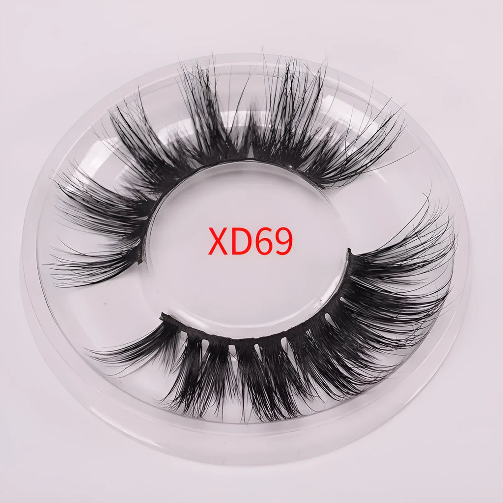 A pair of 5D mink false eyelashes with a double-headed brush and a black hair storage cap on a white background.