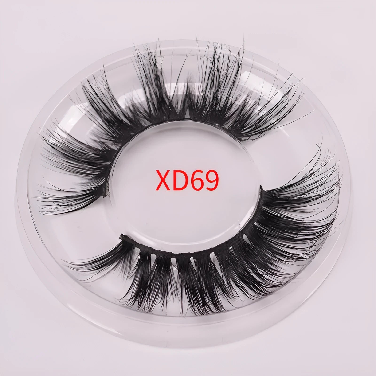 A pair of 5D mink false eyelashes with a double-headed brush and a black hair storage cap on a white background.