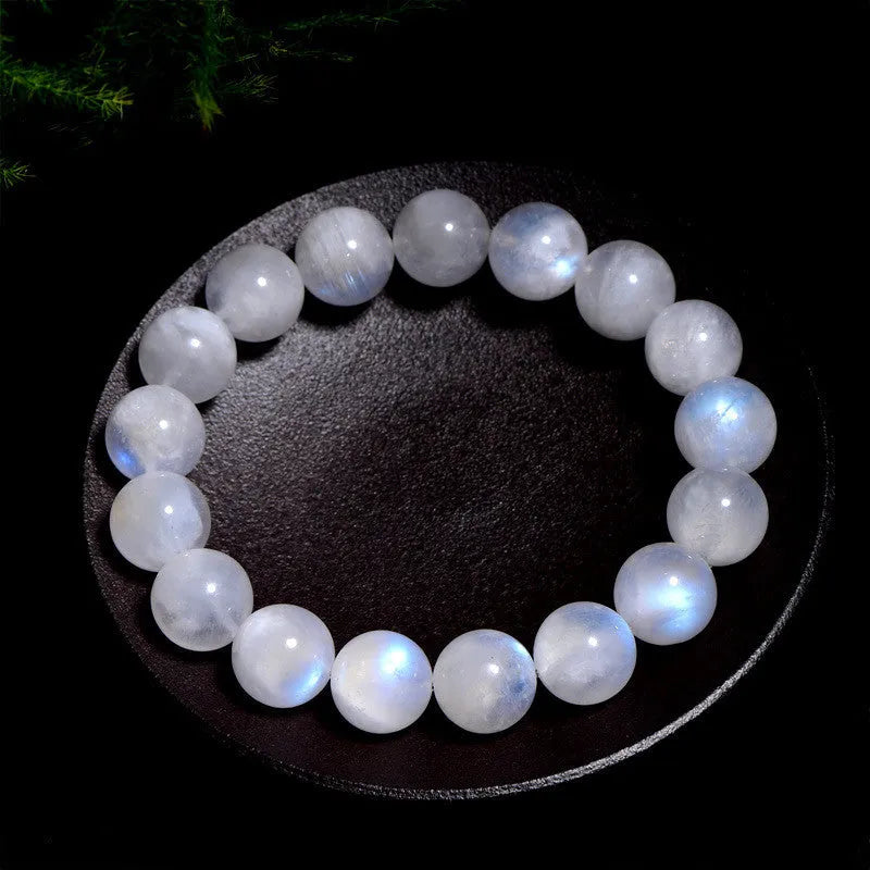 White polished moonstone bead bracelet with blue moonlight sheen, showing round geometric beads.