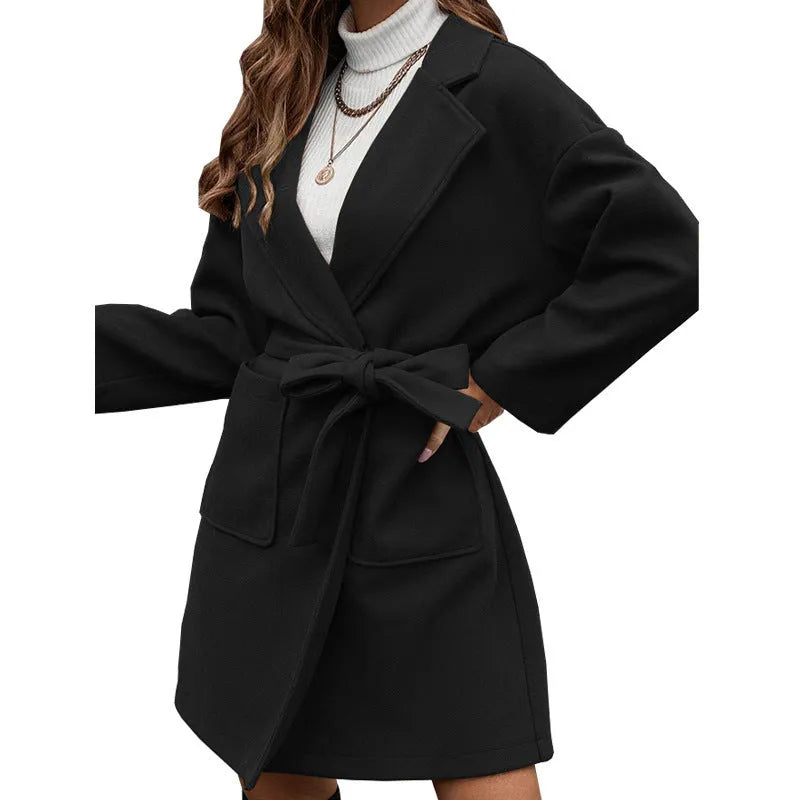 Minimalist long sleeve lapel coat with an adjustable belt and split front in a loose fit.