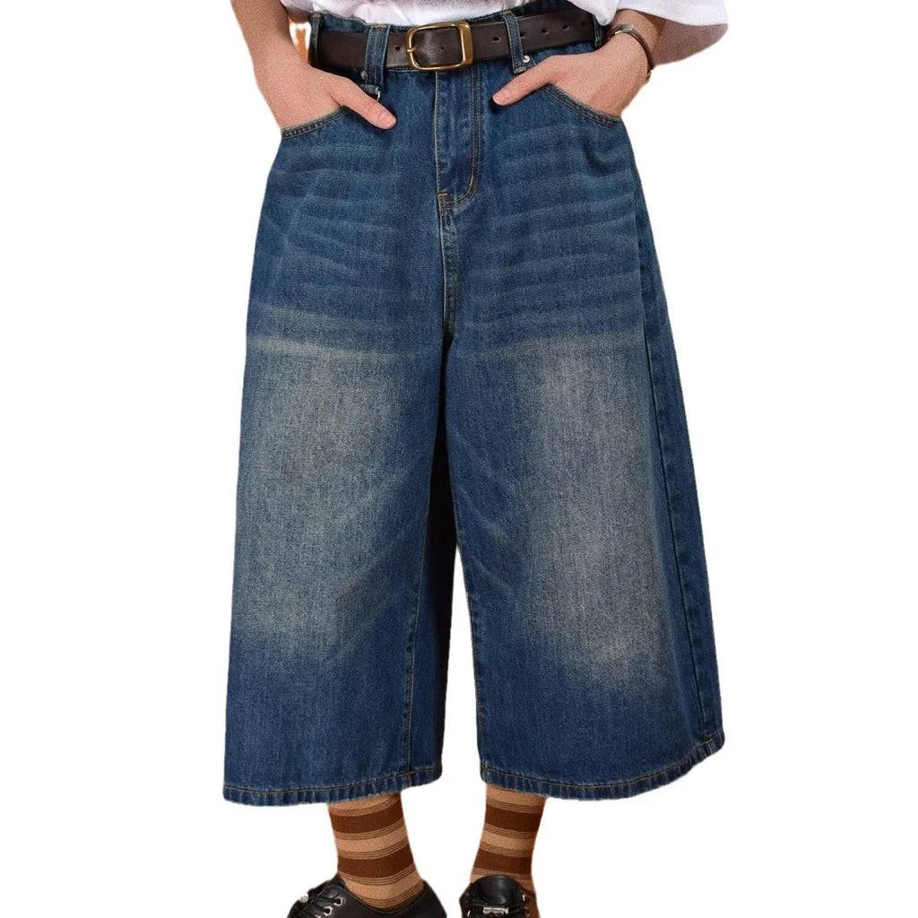Men's loose straight-cut denim shorts in blue shown on a model, featuring a fifth-pants length.