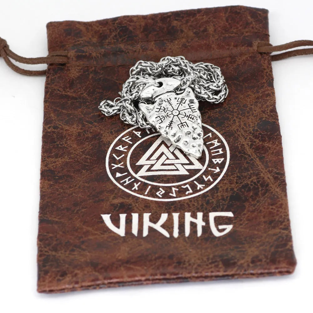Alloy compass pendant necklace with twisted chain on a flat surface showing silver finish