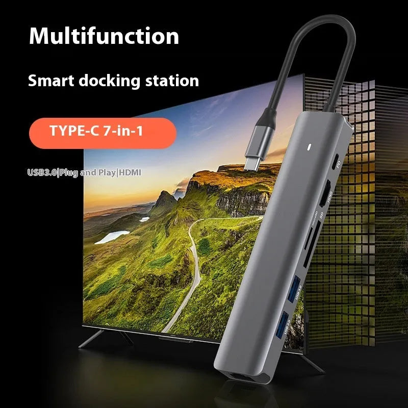 Silver aluminium USB C 7-in-1 hub with HDMI, USB 3.0 ports, and SD card slots.