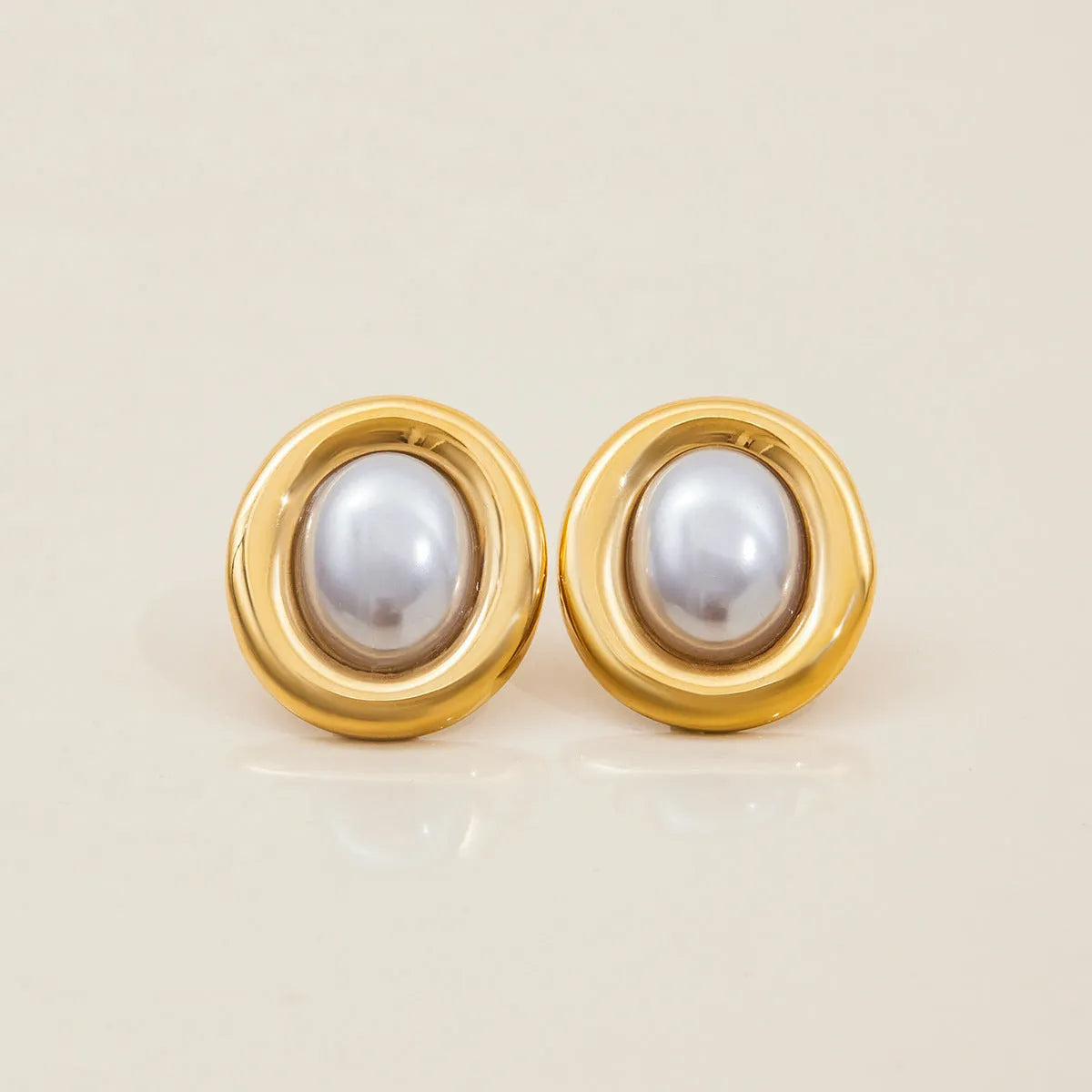 A pair of stainless steel vintage-style pearl stud earrings for women with an electroplated finish.