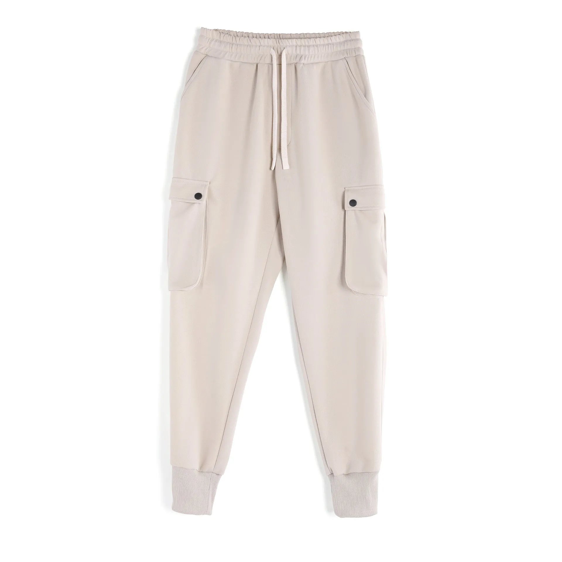 Men's loose fit beige cotton trousers with an ankle tie and multiple pockets on a man standing casually.