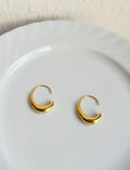 Gold electroplated alloy snake design drop earrings on a neutral background