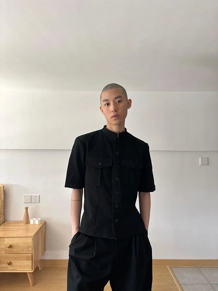 Handmade black loose fit half sleeve hunting shirt with a shirt collar, laid flat.