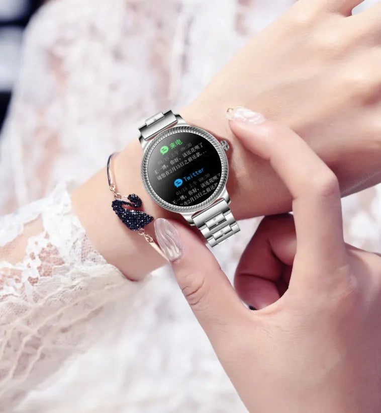 AK38 Ladies Smart Watch with metallic stainless steel band on a wrist, showing its 1.09-inch colour screen.