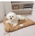 Tied cage cushion for dogs and cats in beige, showing platform attached to wire crate bars – size L.