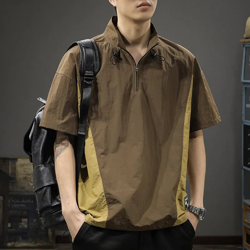 Man wearing a brown short-sleeved shirt with a half-zipped stand collar, showing the loose fit.