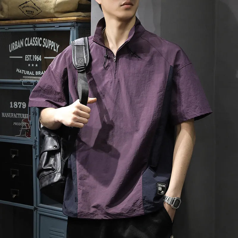 Man wearing a brown short-sleeved shirt with a half-zipped stand collar, showing the loose fit.
