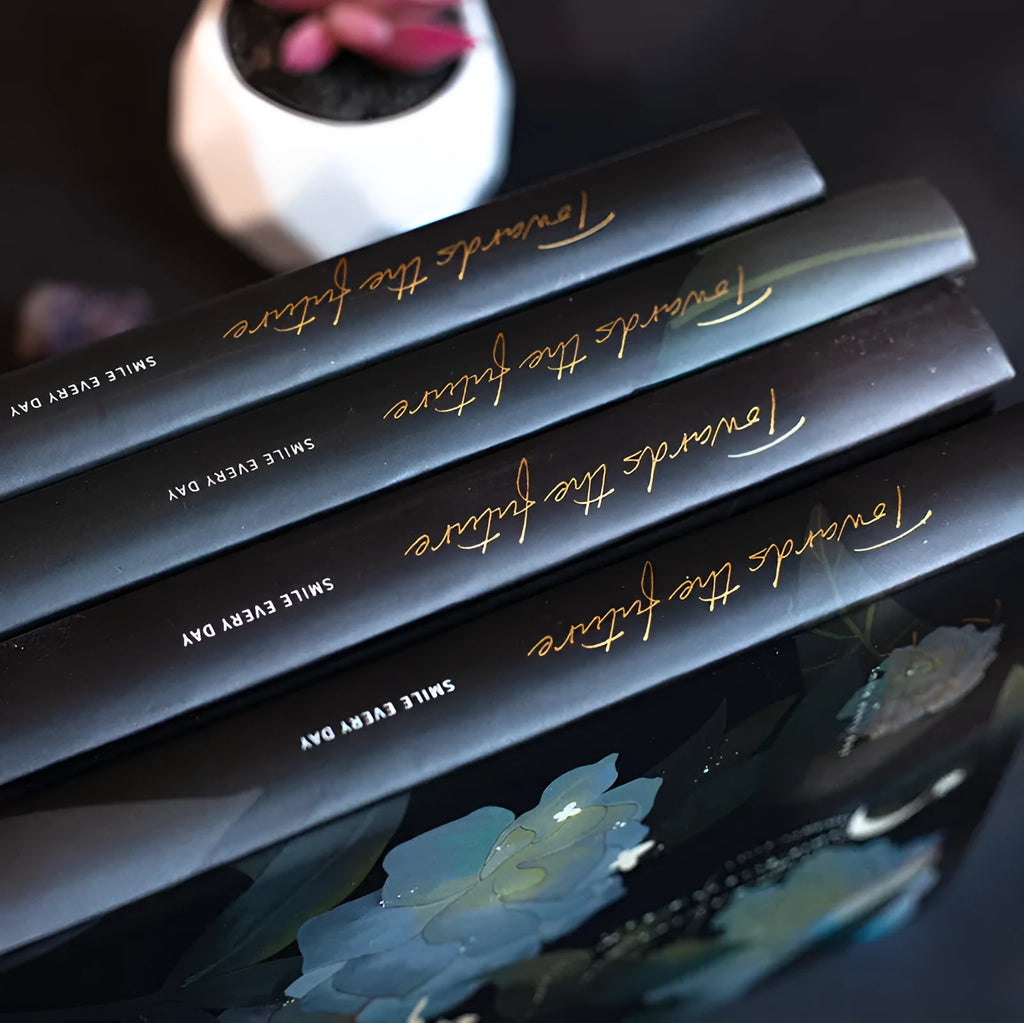 A5 notebook with luminous colourful illustration cover shown in deep blue, gold, light blue, and purple colour options.