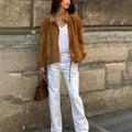 Loose fit solid colour retro jacket with long sleeves on a hanger.
