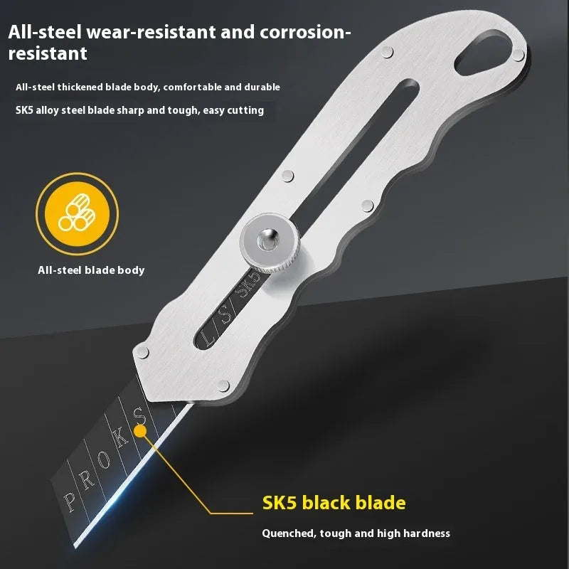 Stainless steel folding art knife with black blade and 20 spare blades on a work surface
