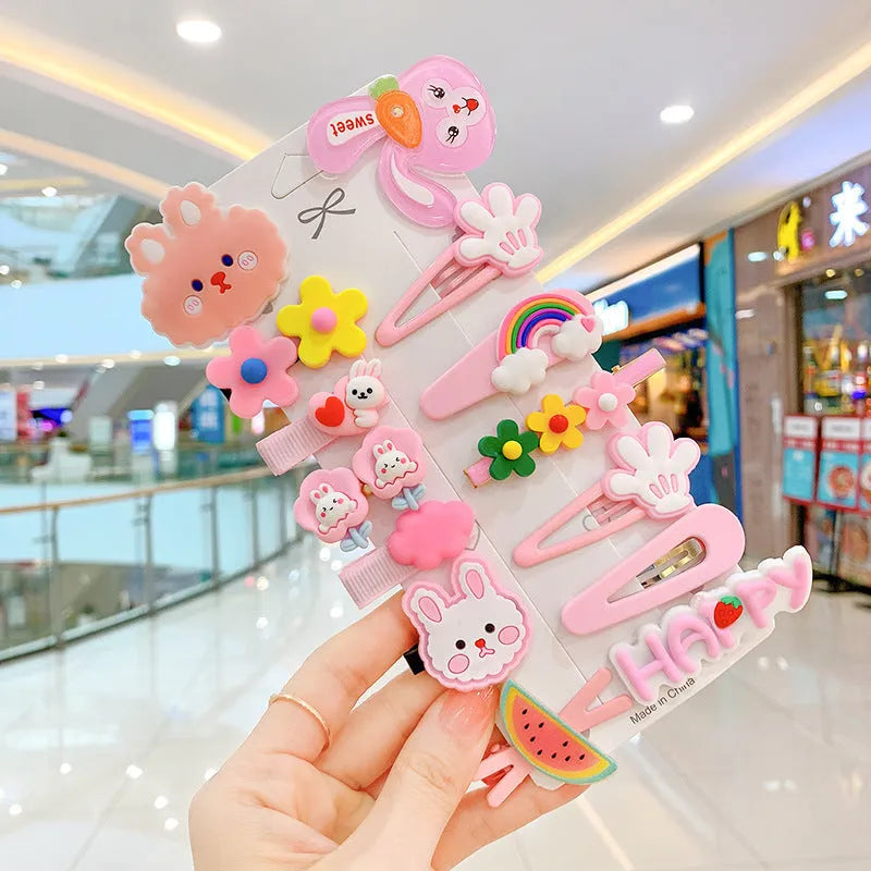 14-piece toddler hair accessories set on display including rainbow barrettes, fruit clips, and butterfly pins in bright colours