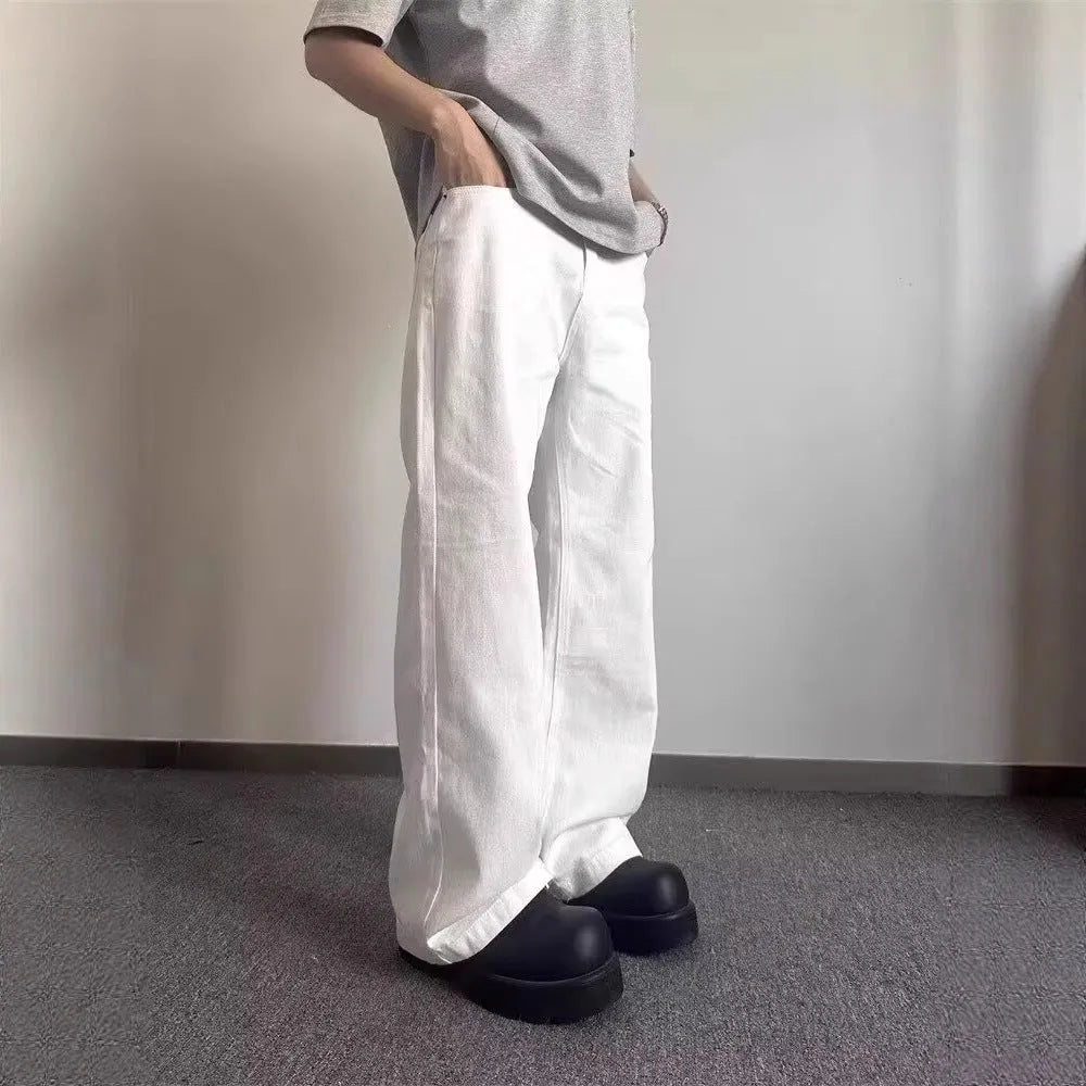 Men's loose fit straight leg white denim jeans on a hanger, showing wide leg opening and zipper fly.