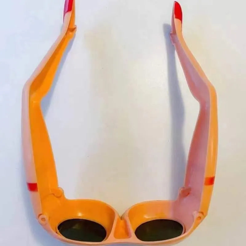 Orange plastic novelty sunglasses shaped like legs and hips on a white background.