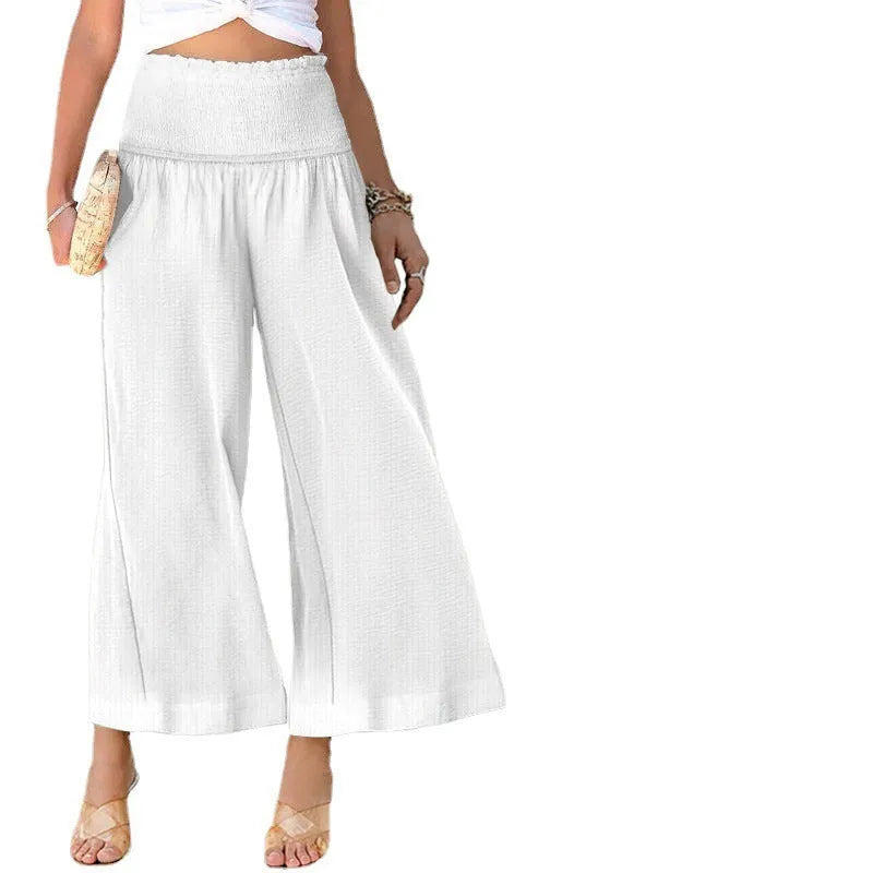 Women's high-waist pleated cotton trousers in a straight-leg cropped style on a neutral background.