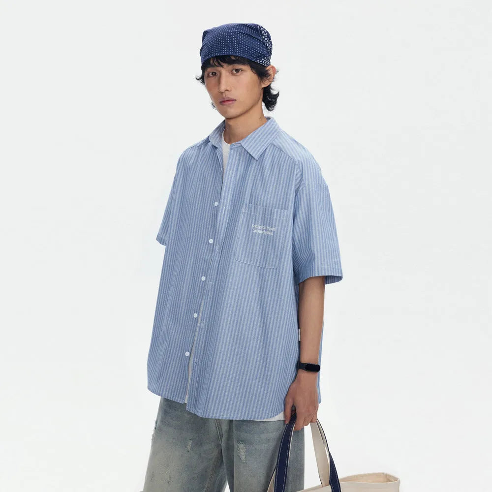 Blue and white striped loose-fit short-sleeved overalls shirt on a hanger