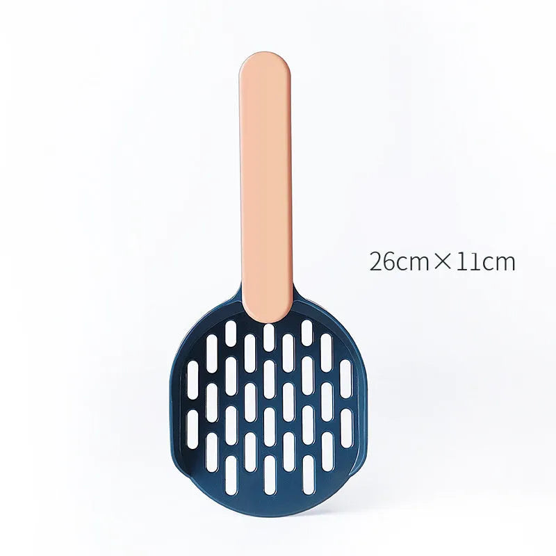 Plastic cat litter shovel in blue, green, and pink colours on a clean surface
