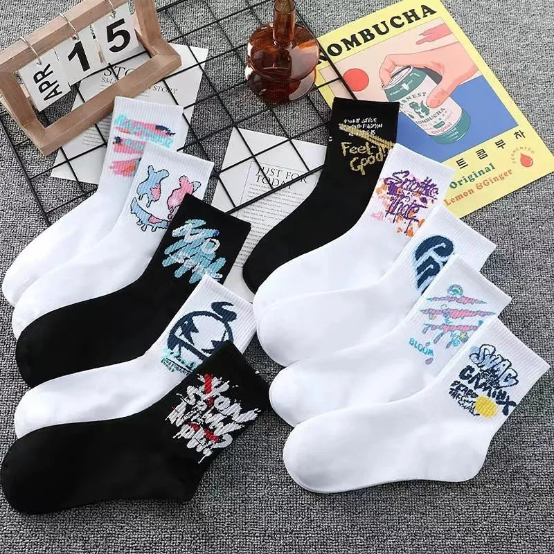 White cotton tube socks with graffiti pattern and middle calf length on plain background