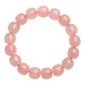 Pink natural crystal barrel bead bracelet with geometric shape on wrist.