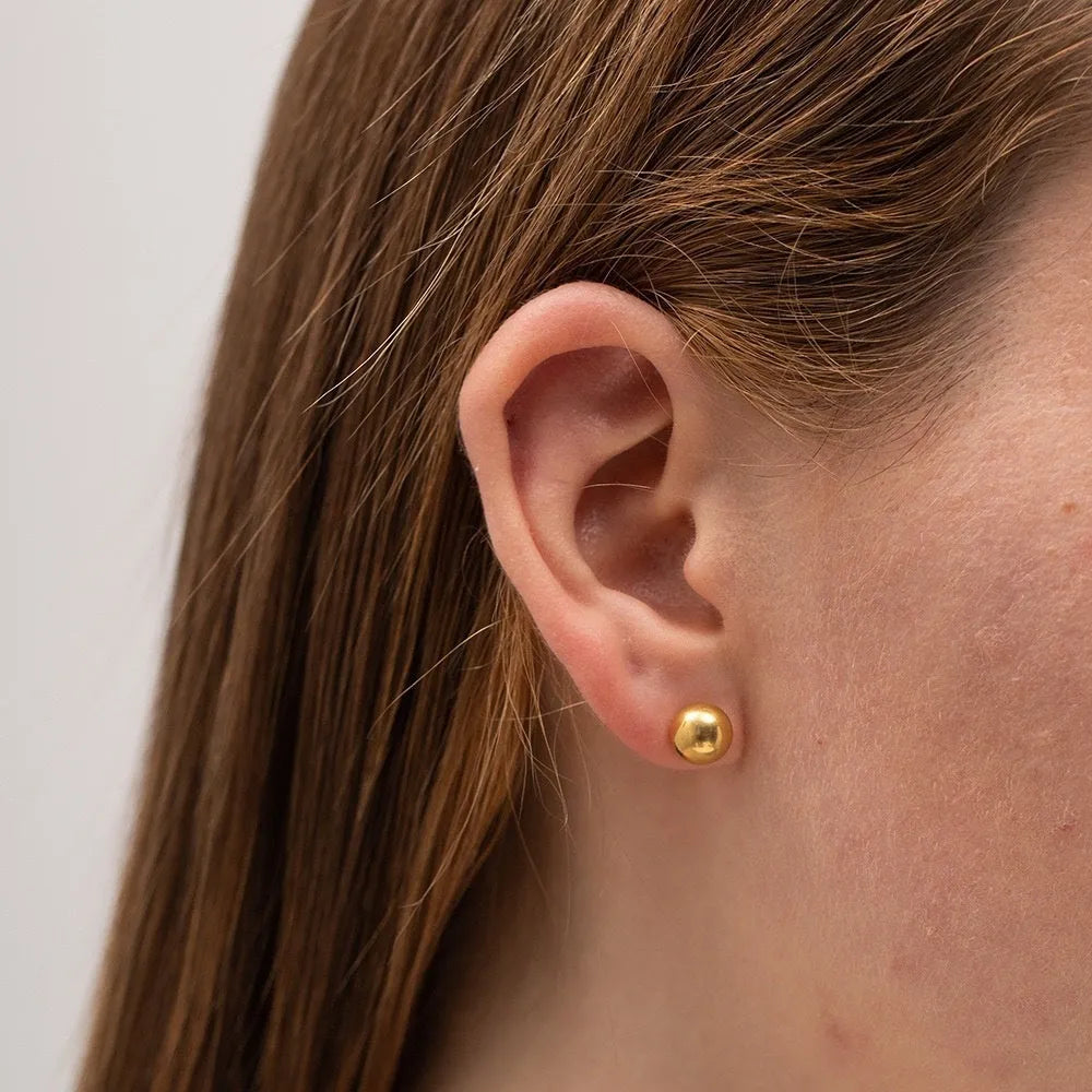 Stainless steel 18K gold ball stud earrings in simple round geometric design on a white background.