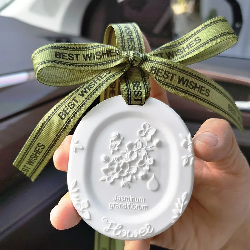 Car aromatherapy stone pendant hanging from rearview mirror with gardenia fragrance option