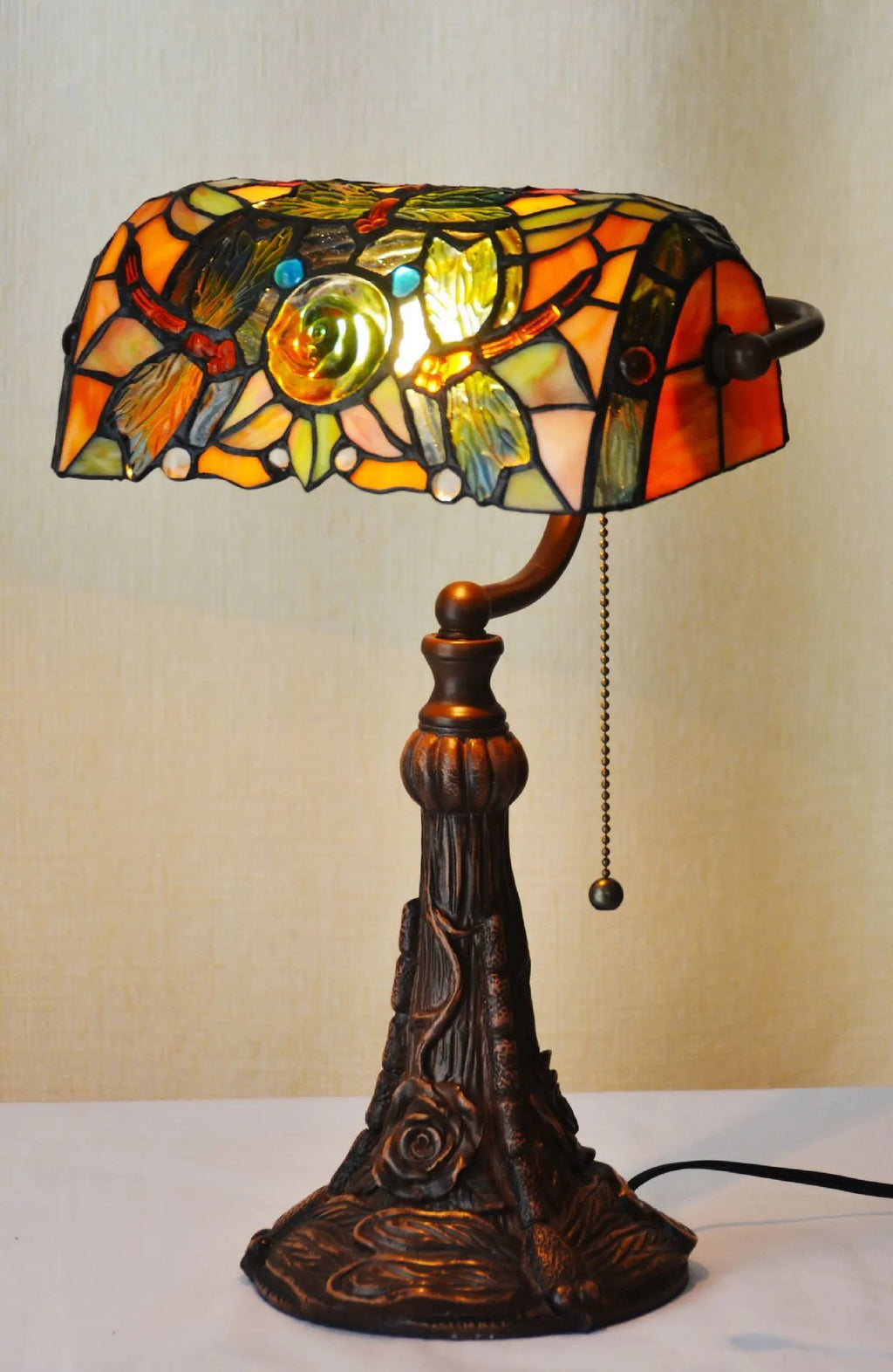 Tiffany table lamp with stained glass shade on resin base, 25cm wide by 36cm tall