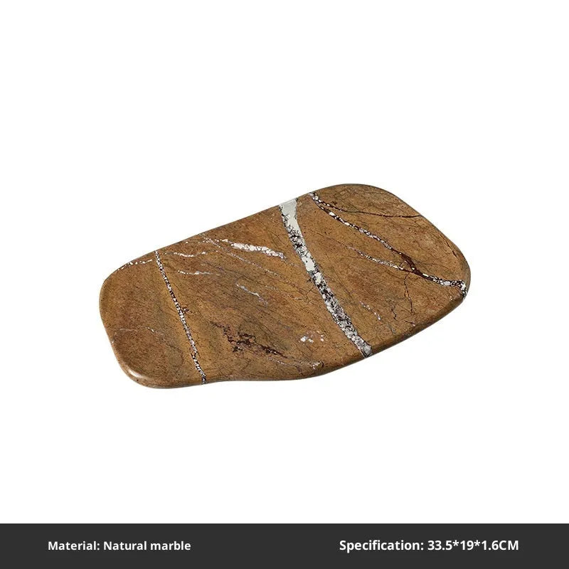 Irregular natural marble tray in coffee colour on a wooden coffee table with decorative objects