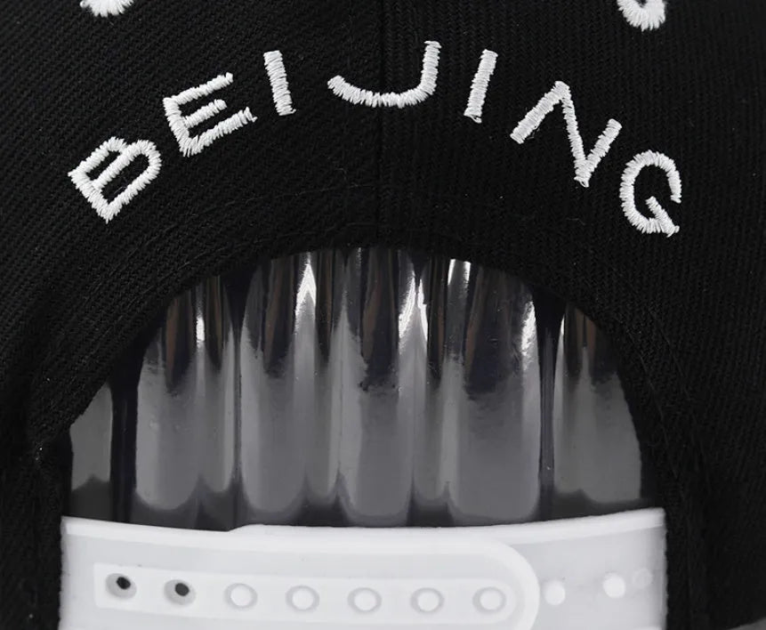 Cotton baseball cap with embroidered letters in black colour showing adjustable strap and dome crown