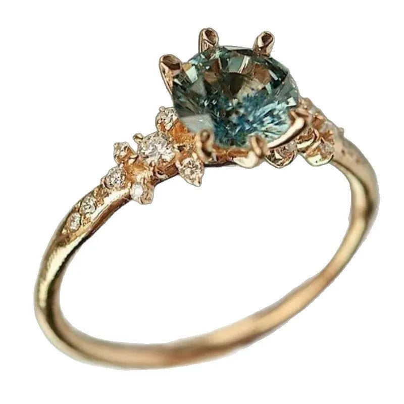 Gold plated unisex ring with a claw-set zircon stone and geometric chamfered square pattern band.