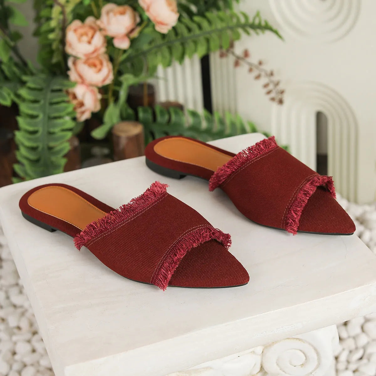 Women's denim slipper with tassel detail in apricot colour, showing flat profile and leather interior.
