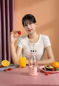 Handheld small electric portable mini juicer in pink with USB charging port and four cutter head